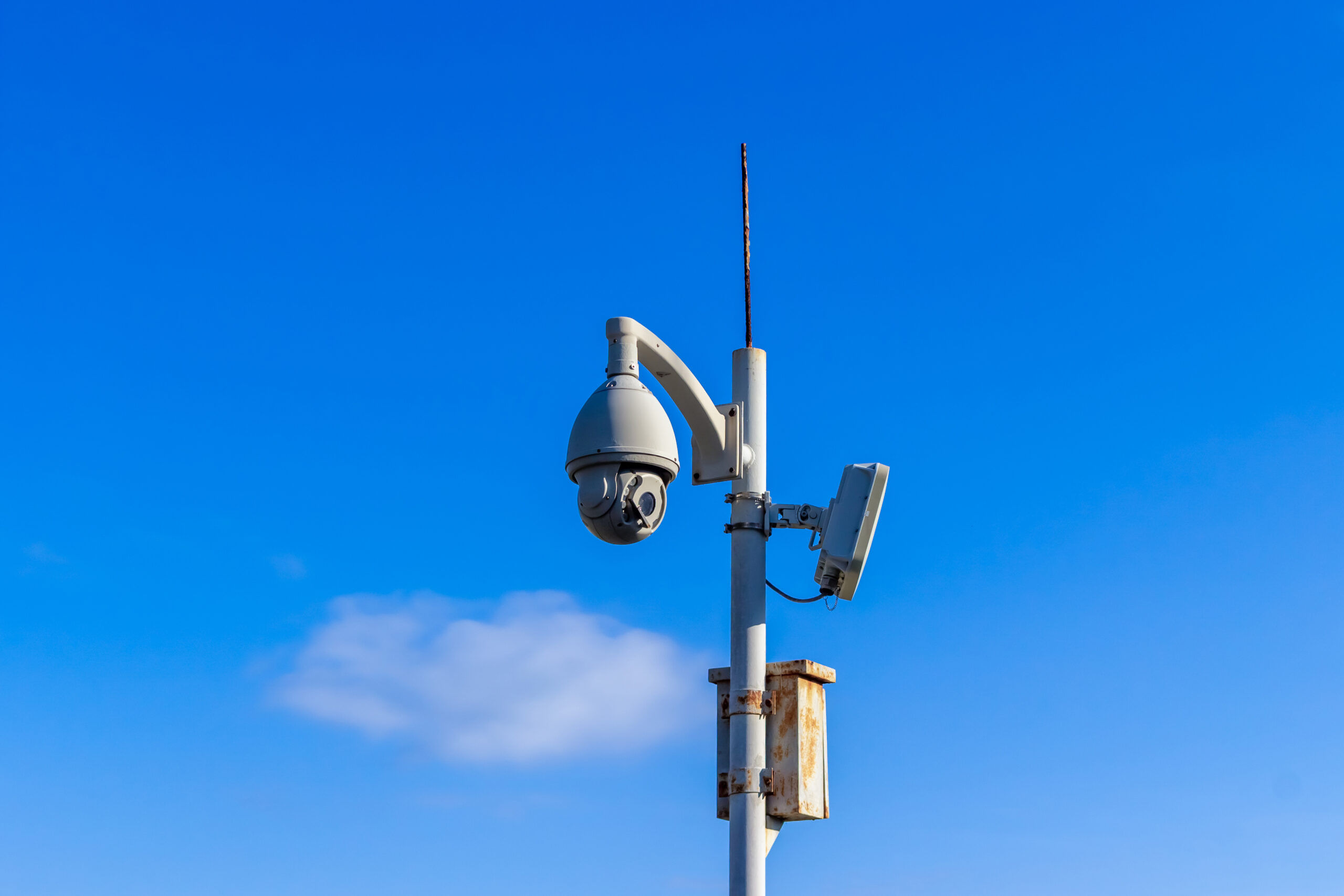 Outdoor Wireless Controlled Security Surveillance Camera on pole against blue sky background