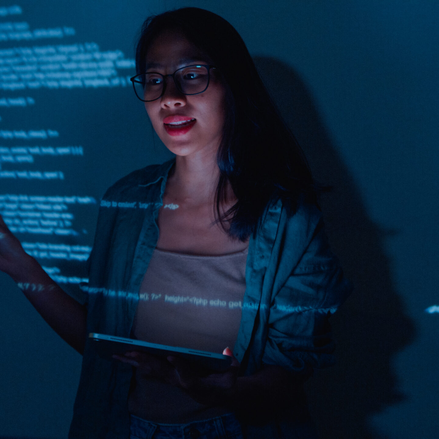 Woman presenting code with tablet and projections