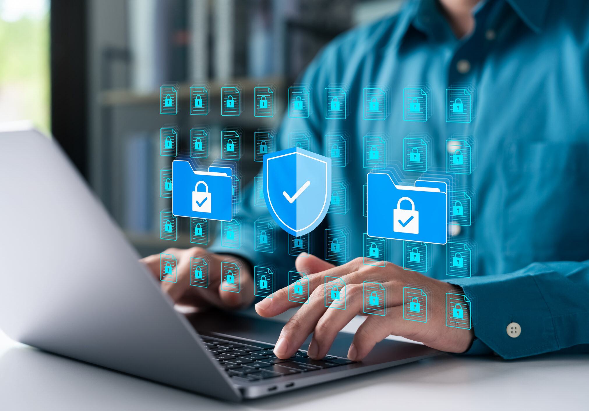 Cybersecurity concept with businessman using a laptop to protect data folders and digital files. Represents data privacy, secure information, and advanced cyber protection.